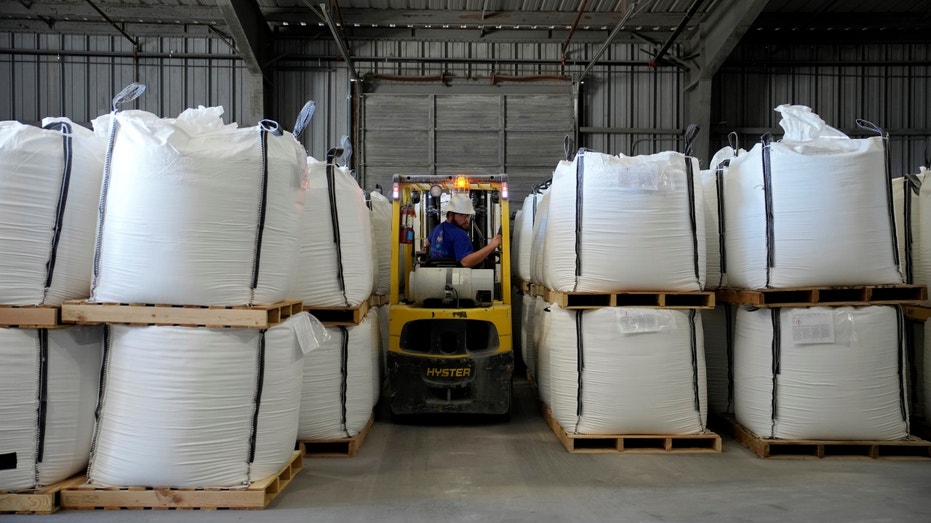 A forklift surrounded by heavy bags of lithium