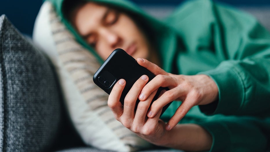 teen on couch on iPhone