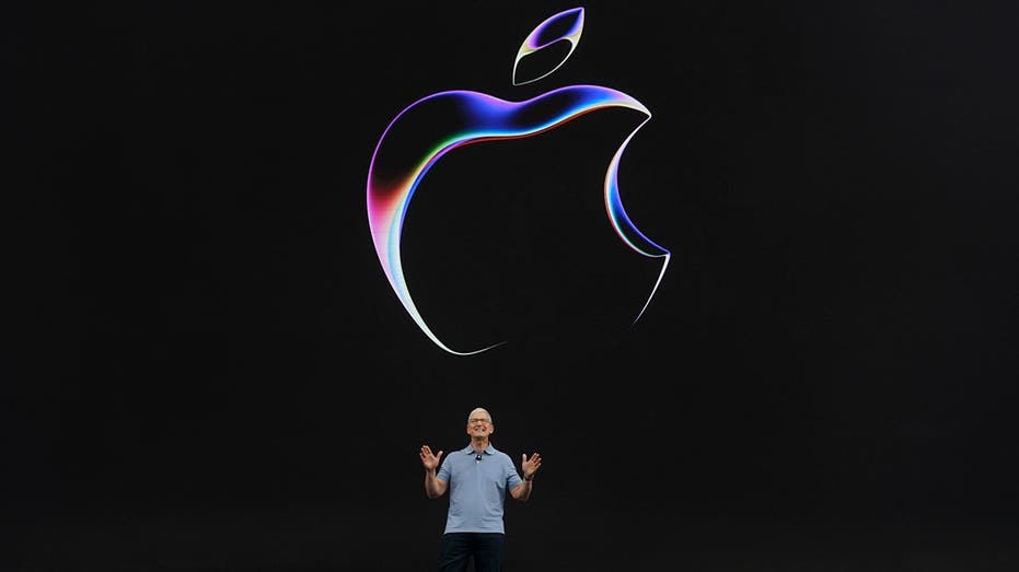 Tim Cook, apple CEO with giant apple logo behind him