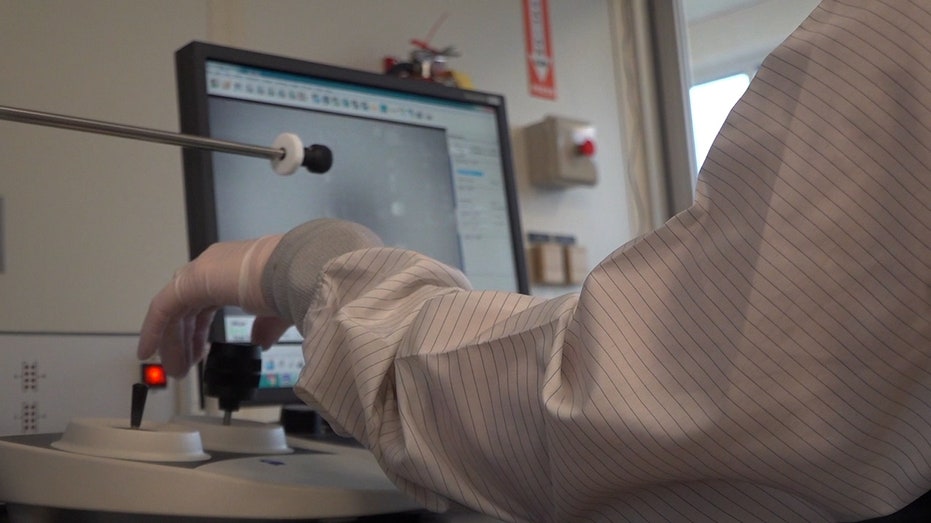 student researcher looks at computer at Oho State