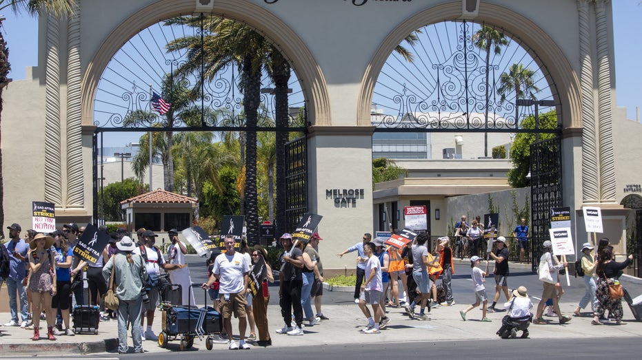 Actors and writers marching in front of Paramount studios