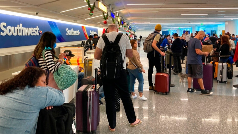 Los Angeles travelers wait at a Southwest Airlines baggage counter