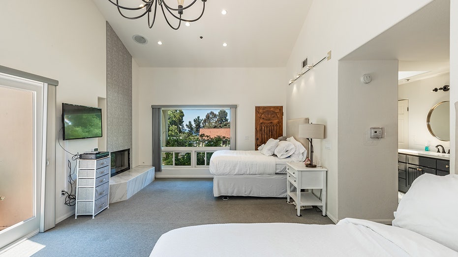 Bedroom with white beds and chandelier