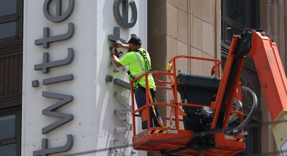 A worker removes letters from the Twitter sign