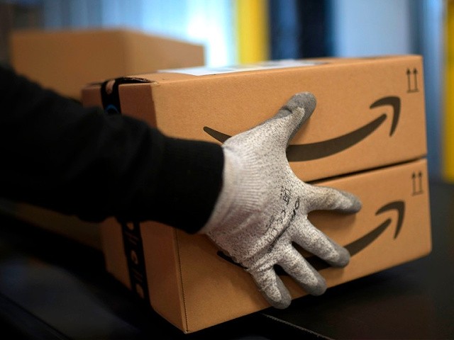 An employee carries a package at the distribution center of US online retail giant Amazon in Moenchengladbach, on December 17, 2019. (Photo by INA FASSBENDER / AFP) (Photo by INA FASSBENDER/AFP via Getty Images)