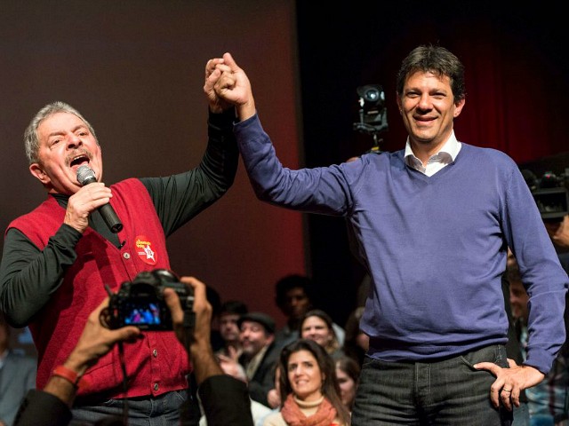 Brazilian former president Luiz Inacio Lula da Silva (L) raises the hand of the mayoral candidate of the Workers Party (PT) Fernando Haddad during a campaign rally in Sao Paulo, Brazil, on September 27, 2012. The Sao Paulo mayoral race pits an ex-television consumer advocate against candidates of Brazil's two main parties for a job seen as a stepping stone to higher national office. With a population of 11 million, Sao Paulo is the country's most populous and wealthiest city, and the contest will be one of the most closely watched in the nationwide municipal elections on Sunday. AFP PHOTO/YASUYOSHI CHIBA (Photo credit should read YASUYOSHI CHIBA/AFP/GettyImages)