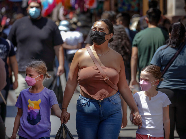 Los Angeles, CA - July 14: Sustained jumps in cases and hospitalizations fueled by the hyper-infectious BA.5 subvariant pushed Los Angeles County into the high COVID-19 community level Thursday, a shift that could trigger a new public indoor mask mandate by the end of this month unless conditions improve. Shoppers in mask and without masks in a very congested market Santee Alley on Thursday, July 14, 2022 in Los Angeles, CA. (Irfan Khan / Los Angeles Times via Getty Images)