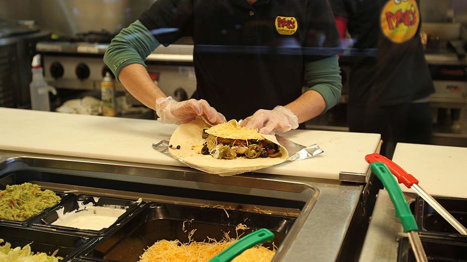 Moe's working making burrito