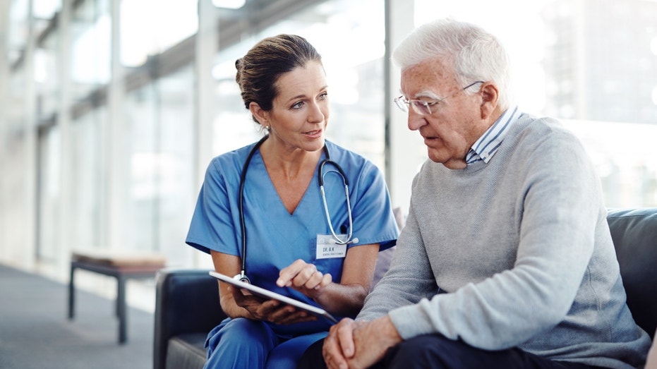 Nurse talking to an elderly patient in a hospital