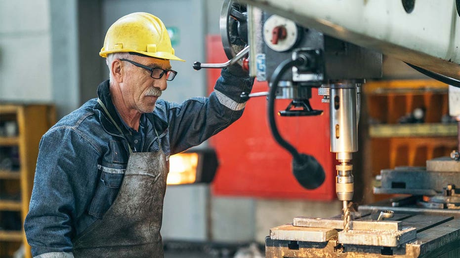 Worker using drill press