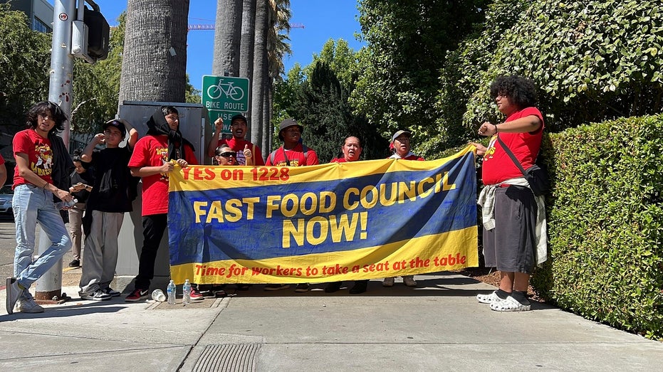 Fast food workers hold a sign that reads "Fast Food Council Now!" outside the California State Capitol in Sacramento