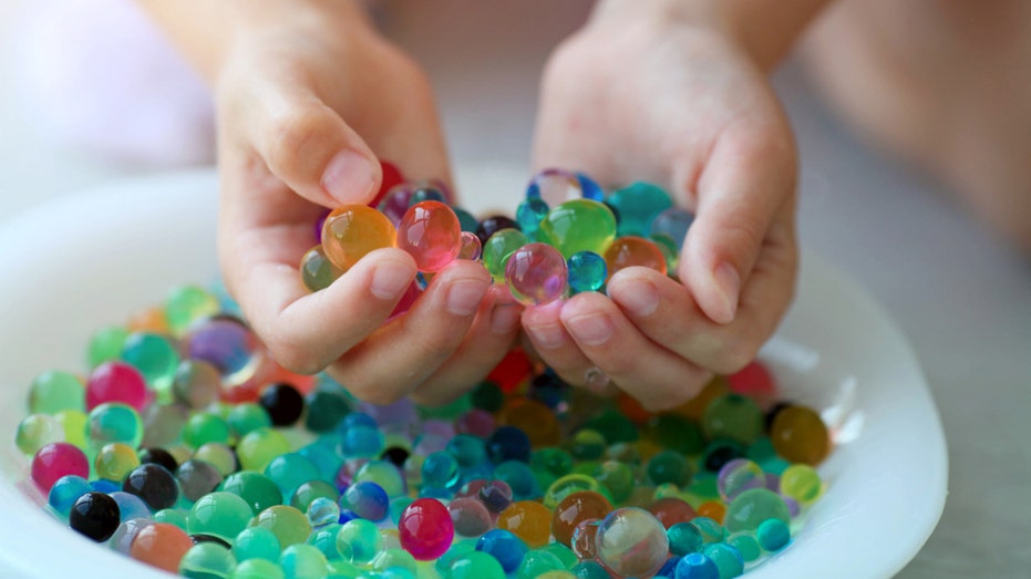 two hands holding water beads