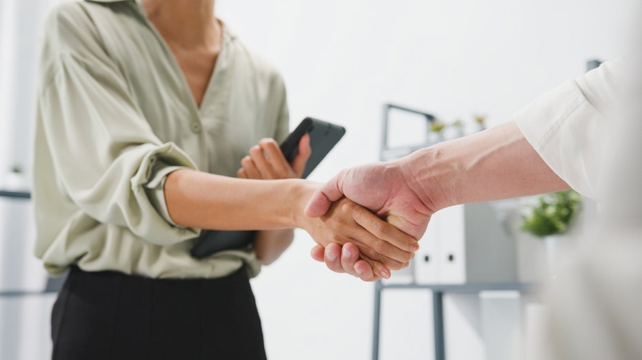 Man and woman shake hands.