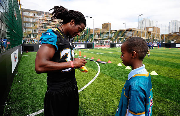 Sergio Brown of the Jacksonville Jaguars signs an autograph for a local school child during the NFL Launch of the Play 60 scheme at the Black Prince...