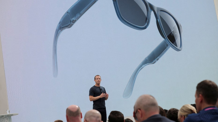 Mark Zuckerberg unveils new jeans-colored Ray-Ban Meta smart glasses in front of a crowd.