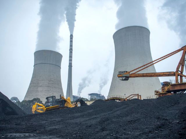 JIANGYOU, CHINA - JANUARY 28: A bulldozer pushes coal onto a conveyor belt at the Jiangyou Power Station on January 28, 2022 in Jiangyou, Mianyang City, Sichuan Province of China. (Photo by Liu Zhongjun/China News Service via Getty Images)