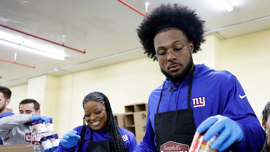 Kayvon Thibodeaux packs box of donated meal