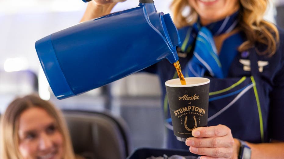 Alaska Airlines flight attendant pours coffee