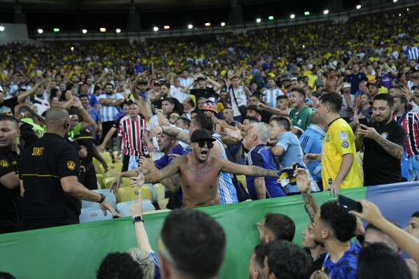 Fans react after a fight between Brazilian and Argentinians fans at the stands prior to a qualifying soccer match for the FIFA World Cup 2026 at Maracana stadium in Rio de Janeiro, Brazil, Tuesday, Nov. 21, 2023. (AP Photo/Silvia Izquierdo)