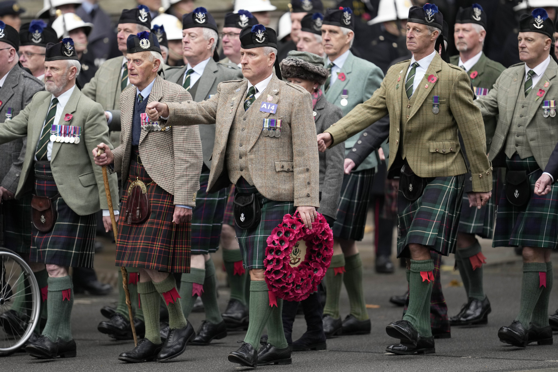 LONDON, ENGLAND - NOVEMBER 12: Veterans carry a wreath as they attend the Remembrance Sunday service at the Cenotaph on November 12, 2023 in London, England. Every year, members of the British Royal family join politicians, veterans and members of the public to remember those who have died in combat. (Photo by Kin Cheung - WPA Pool/Getty Images)