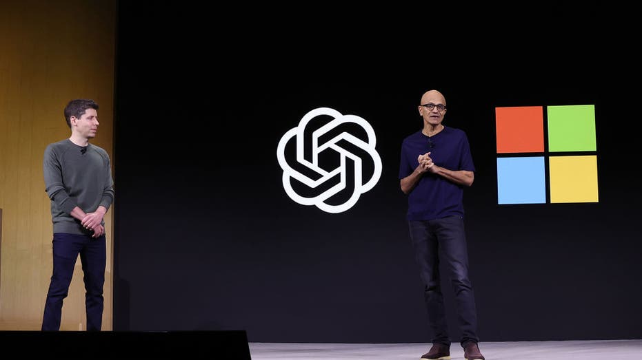 Satya Nadella speaks as Sam Altman looks on