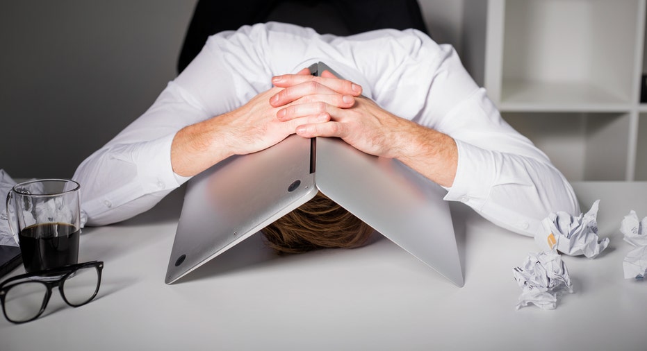 Man hiding under laptop