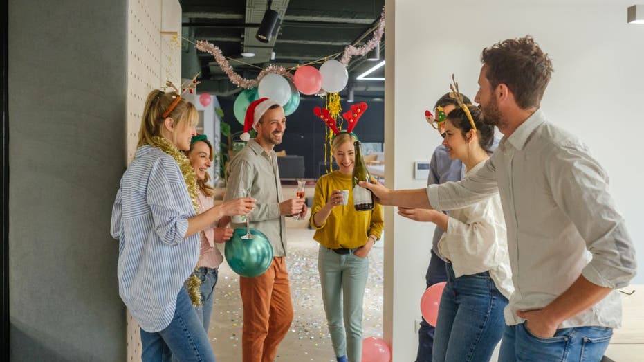 workers toast at in-office holiday party