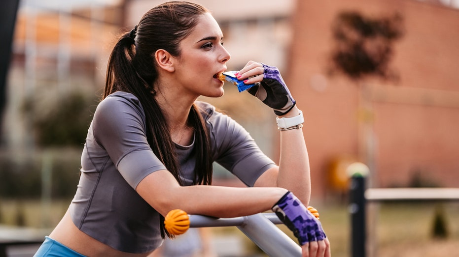 woman eats protein bar