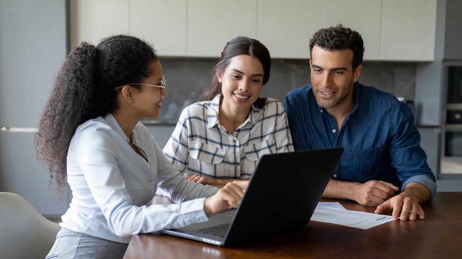 A financial advisor speaks with a woman and man