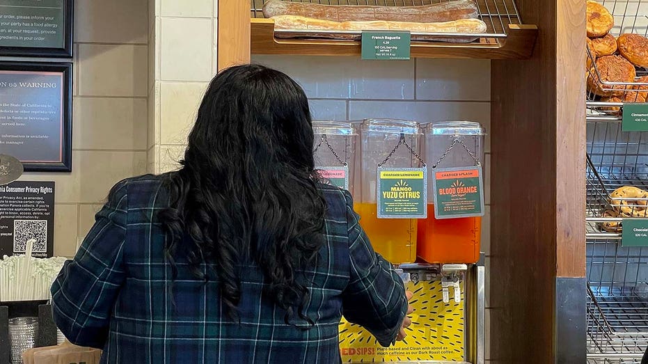 A woman pouring a charged lemonade at Panera