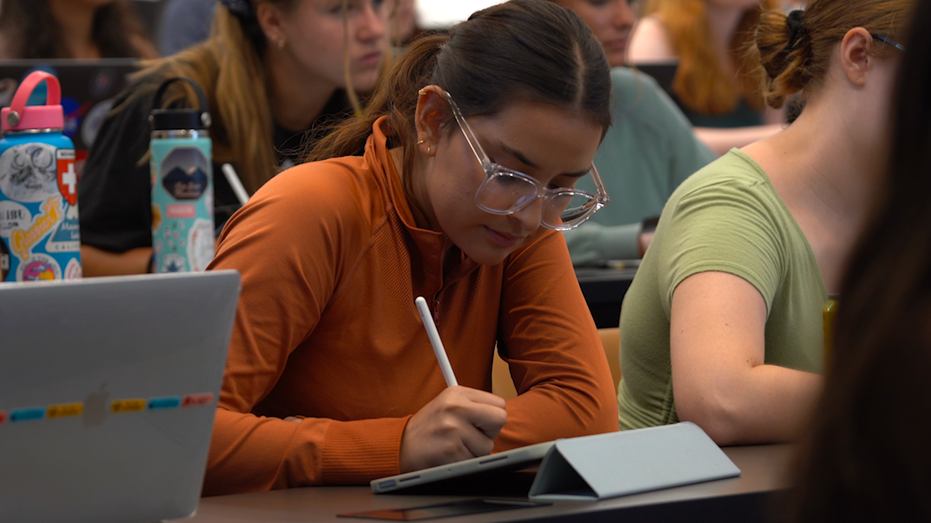 Student taking notes in class at Pepperdine University