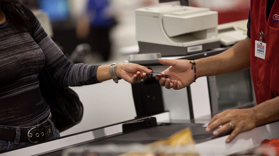 Woman handing over Costco card