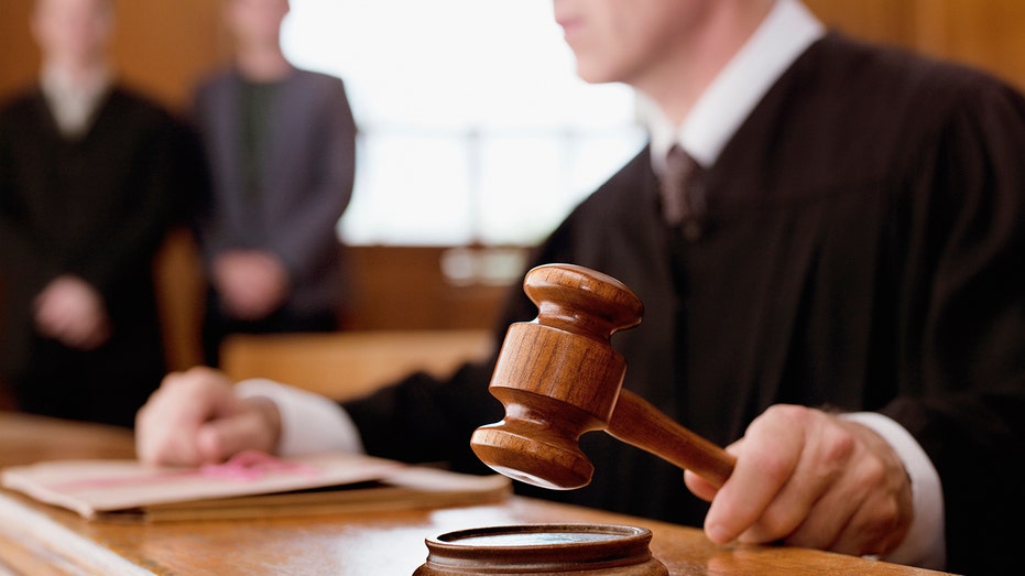 Judge holding gavel in courtroom