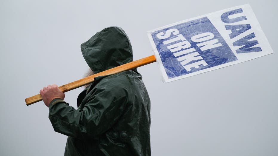 UAW member walking away with strike sign